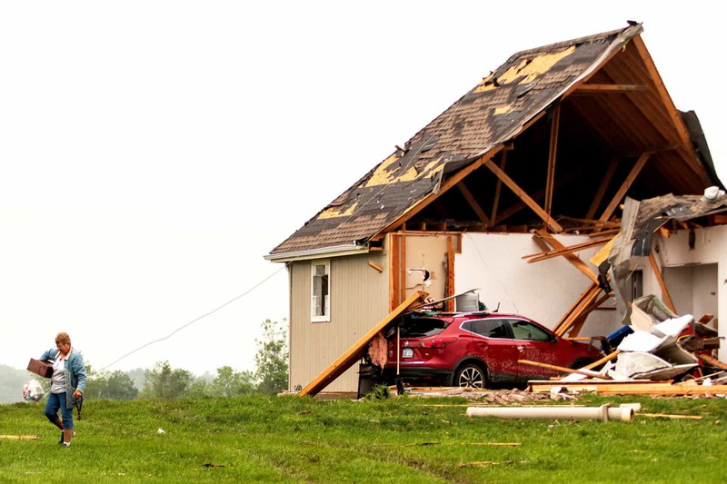 Một người phụ nữ rời khỏi ngôi nhà bị phá hủy sau bão ở Linwood, Kansas, Mỹ.